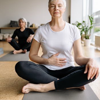 Elderly women practicing yoga indoors for health and wellness.